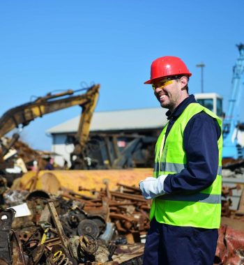 Worker on junkyard. Copy space available.